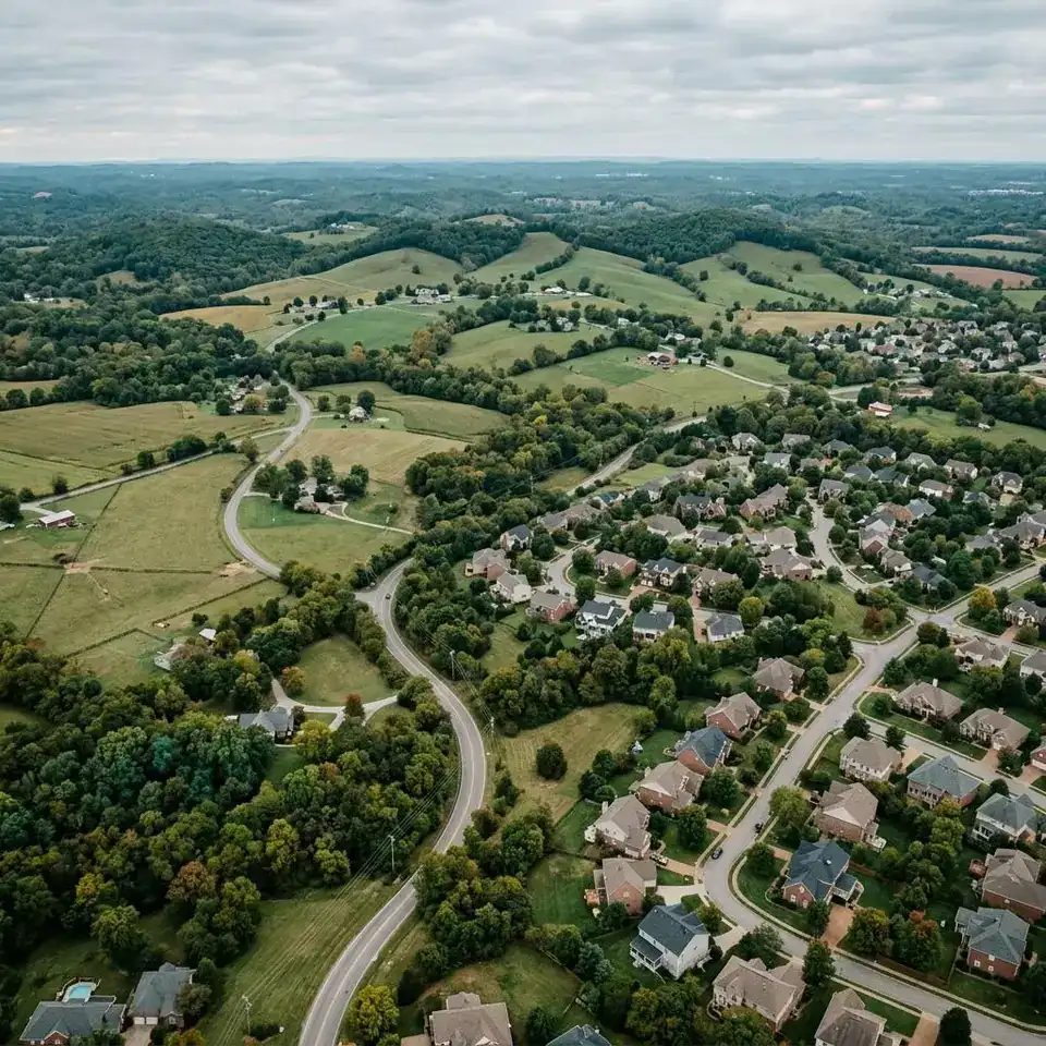 Rolling Middle Tennessee hills with neighborhoods and farmland in late afternoon light